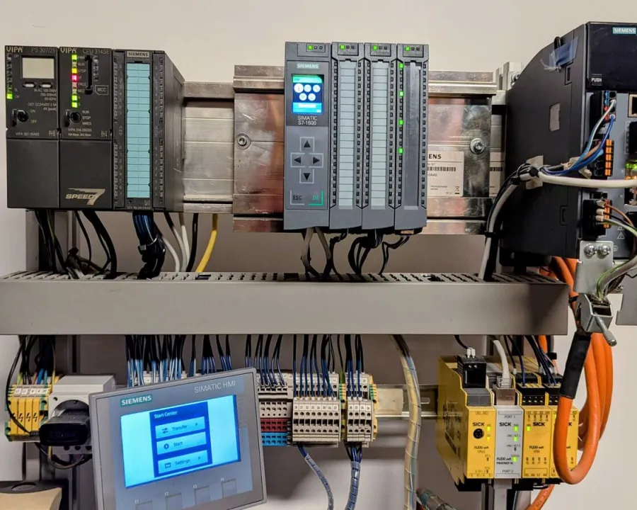 Schulungsaufbau mit VIPA-Steuerung, SIMATIC S7-1500, Antrieb, Bedienpanel und SICK-Sicherheitssteuerung.