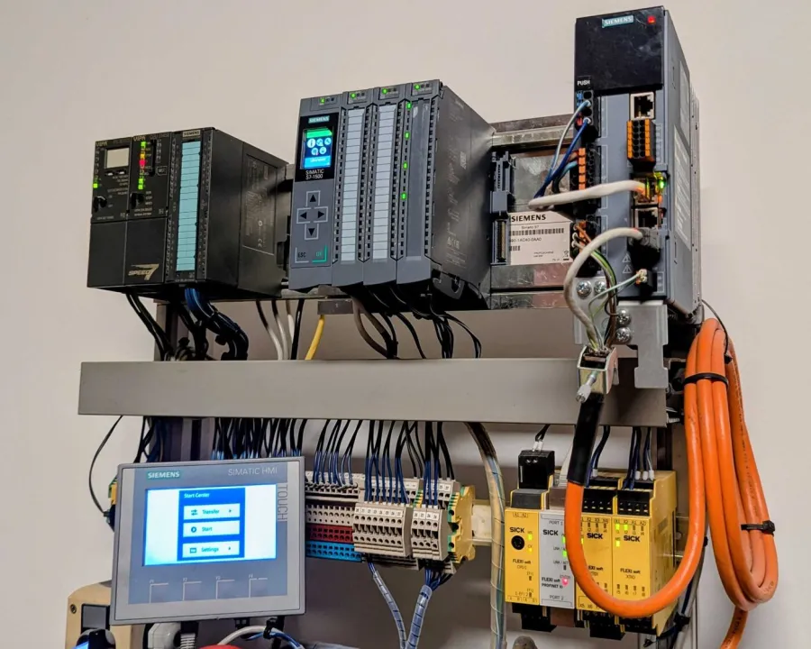 Laboraufbau mit VIPA-Steuerung, SIMATIC S7-1500, Antrieb, SIMATIC-Bedienpanel, Klemmenleiste und SICK-Sicherheitstechnik.